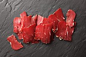 Sliced smoked beef on a slate surface (South Tyrol)