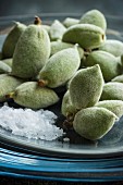 A close-up of green almonds with sea salt on a plate
