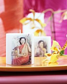 Candle decorated with picture of Oriental woman playing a pipa next to orchid flower