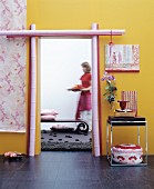 Open doorway frames with painted bamboo poles in yellow wall