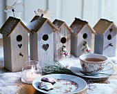 Romantic vintage nesting boxes festively arranged with artificial snow and tea set