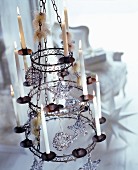 Vintage candle chandelier decorated with Christmas tree baubles and lit candles