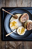 English Muffins mit Honig auf einem Teller (Draufsicht)