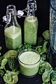 Green smoothies, spinach leaves and a blender
