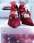 Dark red suede ladies' shoes filled with Chocolate Father Christmases and sweets