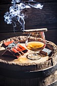 A glass of cognac and cigars on an old wooden barrel