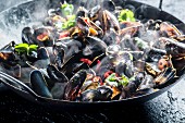 Steaming mussels with spices and chilli rings