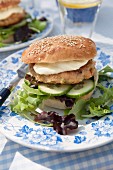 A fish burger with cucumber, lettuce and mayonnaise