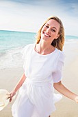 Woman wearing white chiffon dress on beach