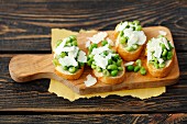 Bruschetta topped with green peas and Parmesan cheese