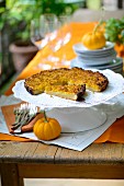 French pumpkin tart on a cake stand on a table outside