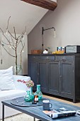 Dark vintage cabinet under sloping ceiling in living room