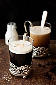 Black coffee with coconut liqueur and cream in vintage glasses
