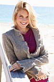 Junge blonde Frau in Top und Strickjacke