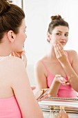 Woman patting powdered paper on face