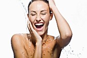 Topless woman under running shower