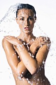 Topless woman under running shower