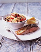 Pasta with a fresh tomato and caper sauce and fried salmon