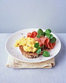 Wholemeal bread topped with scrambled eggs, smoked salmon and water cress