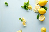 Lemons and basil on a white surface