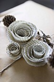 Roses made from pages of old book decorating gift-wrapped present