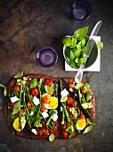 Wholemeal pizza topped with vegetables, feta cheese and egg