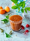 A red smoothie made from raspberries, apricots, courgettes, carrots and stinging nettles