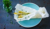 White asparagus with chives in backing paper