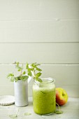 An orange and apple smoothie with spinach and ground ivy