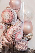 Vintage Christmas baubles with crocheted covers under vintage glass cover