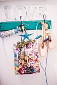 Colourful Christmas gift bag, ballet shoes and headphones hanging from vintage coat rack painted turquoise
