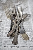 Vintage silver forks on a newspaper