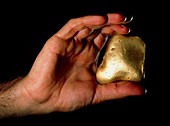 Hand holding nugget of gold