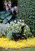Pheasant sculptures in a garden border