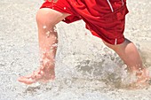 Boy running through sea water at beach