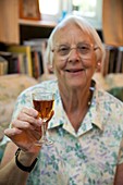 Elderly woman with a glass of sherry