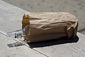Discarded rum bottle in paper bag