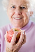 Elderly woman holding an apple