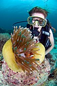 Woman diving with anemone fish