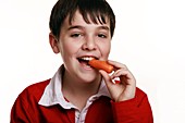 Boy eating a carrot