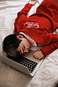 Boy asleep on a laptop computer