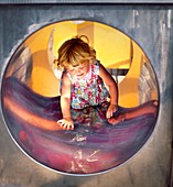 Girl in a playground tunnel