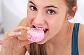 Teenage girl eating a sugary snack