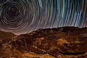 Star trails over rock carvings
