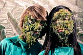 Children's faces covered by plants