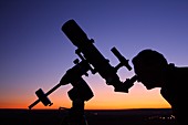 Astronomer using a telescope