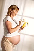 Pregnant woman eating a banana