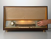 Hand turning on a vintage radio