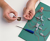 Boy's hands attaching wires