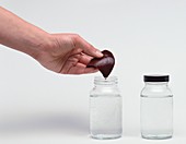 Hand putting liver into jar